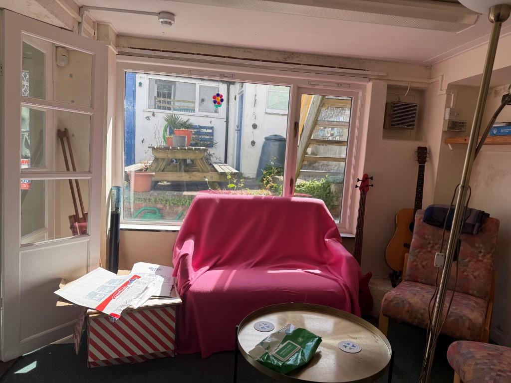 Lot: 129 - COMMERCIAL PROPERTY FOR UPDATING WITH PARKING AND OFFERING POTENTIAL - Lower ground floor sitting room with view of outside area